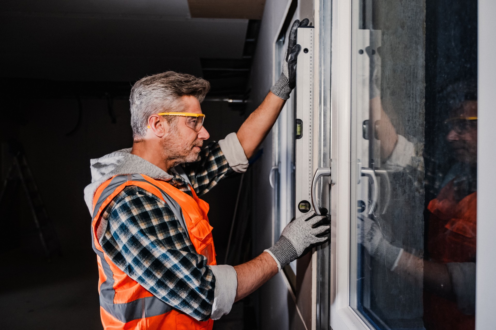 Window Installer Aligning Frame with Spirit Level During Sliding Door Setup